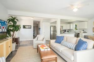 Una sala de estar con un sofá blanco y almohadas azules. en Pier Pressure, en Greenbackville