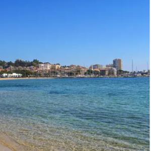 a view of a beach with a city in the background at Studio proche plage et centre-ville in Sainte-Maxime