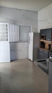 a kitchen with a white refrigerator in a room at Apartamento térreo no Centro in Sorriso +7 photos