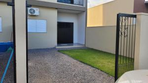a door to a building with a yard of grass at Apartamento térreo no Centro in Sorriso