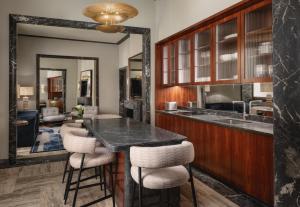 a kitchen with a bar with stools and a living room at Palazzo Ottaviani - Luxury Apartments in Florence