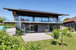 基姆湖畔格斯塔特LIEBLINGSECK nachhaltige 5-Sterne Ferienwohnung - Direkt am Chiemsee的玻璃外墙房子的图象