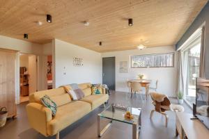 ein Wohnzimmer mit einer Couch und einem Tisch in der Unterkunft LIEBLINGSECK nachhaltige 5-Sterne Ferienwohnung direkt am Chiemsee in Gstadt am Chiemsee