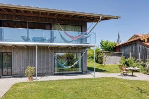 ein Haus mit einer Hängematte, die seitlich hängt in der Unterkunft LIEBLINGSECK nachhaltige 5-Sterne Ferienwohnung direkt am Chiemsee in Gstadt am Chiemsee