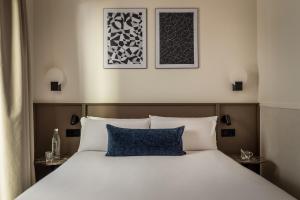 a bedroom with a white bed with a blue pillow at BYPILLOW Sinfonía in Valencia +56 photos