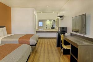 a hotel room with two beds and a desk with a television at Motel 6 Sullivan MO in Sullivan