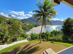 a palm tree sitting on top of a sandy beach at VISTA DESLUMBRANTE APTO 709 in Ubatuba