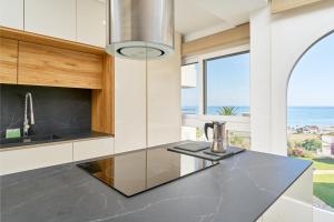 a kitchen with a black counter top with a view of the ocean at Apartamento Mejor Clima Europa in Torrox Costa