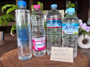 three bottles of water sitting on a table at IZU Elysian View in Koura