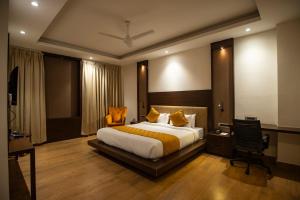 ein Schlafzimmer mit einem großen Bett und einem Schreibtisch in der Unterkunft Rohika AAU-IGH in Guwahati