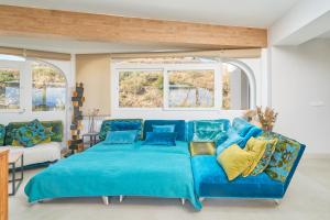 a blue bed in a room with two windows at Apartamento Mejor Clima Europa in Torrox Costa