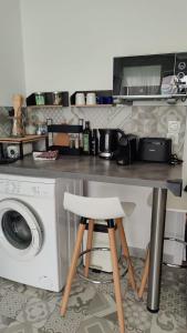 cocina con mesa y lavadora en Carré d'Or - Studio lumineux à 5 minutes de la plage, en Niza