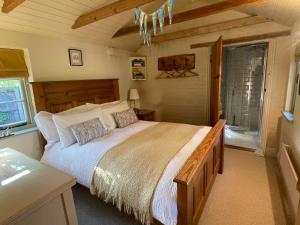 ein Schlafzimmer mit großem Bett und Fenster in der Unterkunft Dairy Cottage Luxury B&B in Attleborough
