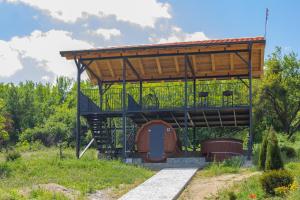 a tree house with a porch and a deck at Etno selo Čubura in Čubura