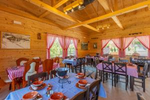 a dining room with tables and chairs and wooden walls at Etno selo Čubura - Apartmani in Čubura