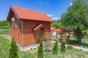 a log cabin with a porch and a gazebo at Etno selo Čubura in Čubura