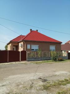 a house with a red roof and a fence at Bandi Vendégház in Verpelét