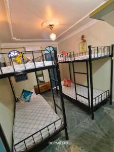a room with three bunk beds in a room at Shared Bed Hostel in Patna +4 photos