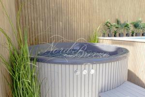 wanna z hydromasażem siedząca przed budynkiem w obiekcie Domki Nord Breeze z podgrzewanym basenem i jacuzzi we Władysławowie
