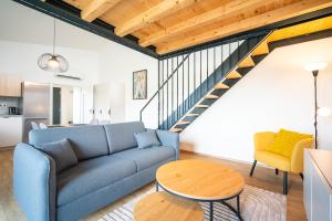a living room with a blue couch and a staircase at Pálava Lake Apartments in Pasohlávky