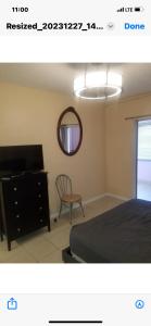 a bedroom with a bed and a dresser and a mirror at Florida Condo By the Beach in JFK Medical Center Incorporated Heliport