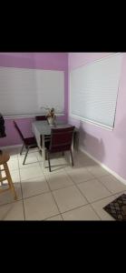 a dining room with a table and chairs and purple walls at Florida Condo By the Beach in JFK Medical Center Incorporated Heliport