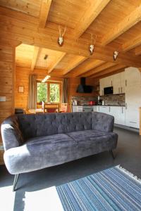 a leather couch in a living room with a kitchen at AlpenChalets Ausseerland in Bad Mitterndorf