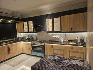 Una cocina con gabinetes de madera y un horno de estufa. en شقة 3غرف نوم في ضاحية الرشيد, en Amán