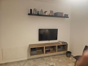 TV de pantalla plana en la parte superior de un centro de entretenimiento en شقة 3غرف نوم في ضاحية الرشيد, en Amán