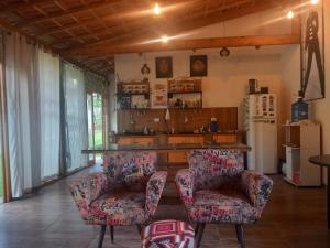 sala de estar con 2 sillas y nevera en Compostela Pousada Hostel & Camping, en São Bento do Sapucaí