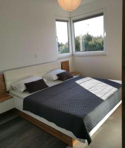 Un dormitorio con una cama grande con dos ventanas. en Apartment Gelo, en Okrug Donji 13 fotos más