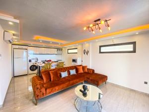ein Wohnzimmer mit einem braunen Sofa und einer Küche in der Unterkunft Villa Irmak İslamlar in Kaş