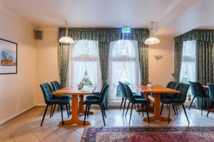 a restaurant with two tables and chairs and windows at Hotel Thesdorfer Hof in Pinneberg