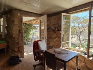 uma sala de jantar com uma mesa e uma janela em בית הסופר- בית בכרם em Mitzpe Ramon