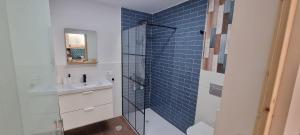 a bathroom with a sink and a shower with blue tiles at Lagarto Playas Majoreras in Las Playas +28 photos