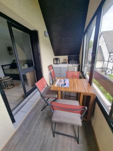 a dining room with a table and chairs at Appartement cosy avec piscine chauffée ouverte du 15-06 au 15-09 in Cabourg +11 photos