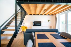 a living room with a blue couch and a table at Pálava Lake Apartments in Pasohlávky
