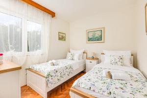 a bedroom with two beds and a window at Villa Gisela in Malinska