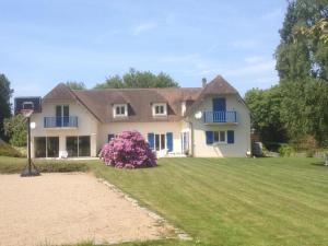 a large white house with a yard with a yard at Garden-level studio in Hautot-sur-Mer
