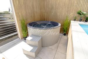 wanna z hydromasażem na patio przy basenie w obiekcie Domki Nord Breeze z podgrzewanym basenem i jacuzzi we Władysławowie