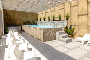 restauracja z basenem i białymi krzesłami w obiekcie Domki Nord Breeze z podgrzewanym basenem i jacuzzi we Władysławowie