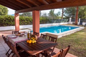 a table with fruit on it next to a swimming pool at Villa Menorca cerca del mar Alcudia in Alcudia