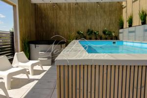 patio z basenem i 2 krzesłami w obiekcie Domki Nord Breeze z podgrzewanym basenem i jacuzzi we Władysławowie