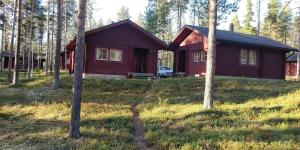 a red house in the middle of a forest at Cottage on Lake Jeris in Muonio