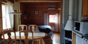a kitchen and dining room with a table and chairs at Cottage on Lake Jeris in Muonio