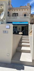 a white building with stairs in front of it at La casa de Lucas in Orihuela