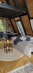 a bedroom with a bed and a table in a attic at Cabana A-Frame pé na represa com translado de barco in Natividade da Serra