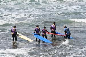 a group of people standing in the ocean holding surfboards at 70's Hostel in Ericeira