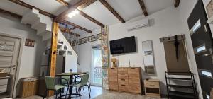 a living room with a table and a tv on the wall at Balatomi Apartman in Balatonföldvár +9 photos