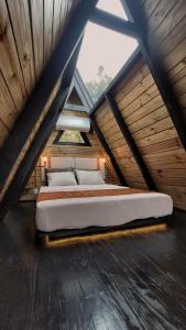 a bed in the attic of a wooden house at Cabana A-Frame pé na represa com translado de barco in Natividade da Serra